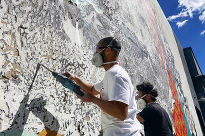 example of vhils engraving on a cement wall to make a large scale realistic portrait commissioned by council legislation