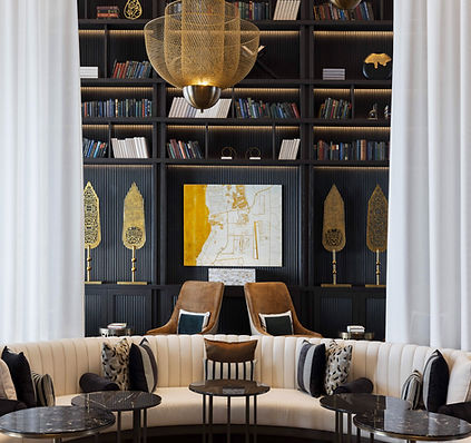 example of curated art collection by artelier art consultants for raffles al areen palace bahrain, photographed by tooze studio and in the library of the luxury hotel development, including a semi circular sofa, gold leaf map by ewan david eason and golden spears with arabic calligraphy depicting a poem