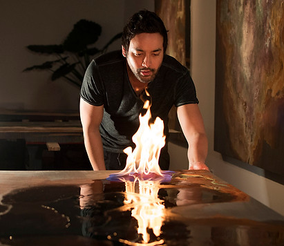 studio shot of tobias tovera in the galleries looking at a flame lighting up his artwork in the making process for a custom job under artelier