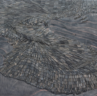 A grey wood art design, made from bespoke carved wood arranged in a fluid design by Artelier art consultancy.