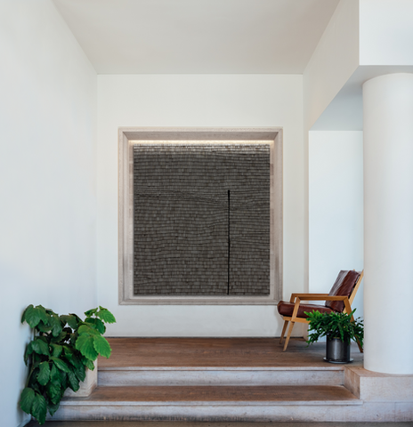 wycliffe stutchbury's wooden chip black square large scale artwork in situ of a contemporary villa space paired with a lounge mid century chair, designed and curated by artelier art advisor's based in the uae