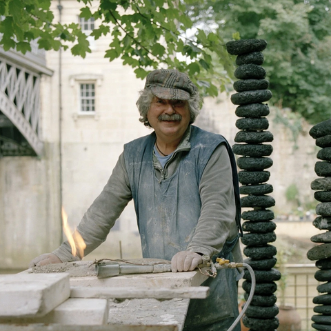 portrait photograph of peter hayes smiling as he attends his workshop doing raku fired ceramics