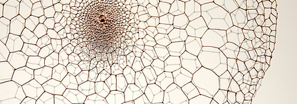 delicate wire artwork with small grey circular forms